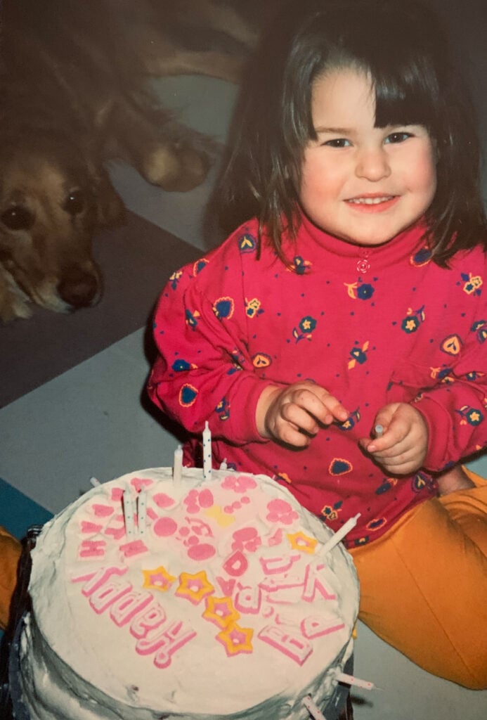 jocelyn as a toddler with the first cake she decorated