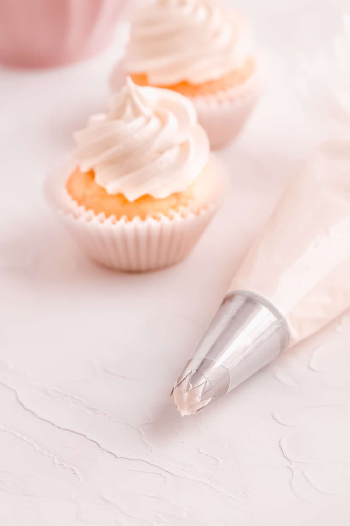 easy vanilla buttercream frosting swirled on cupcakes from a pastry bag fitted with a star piping tip