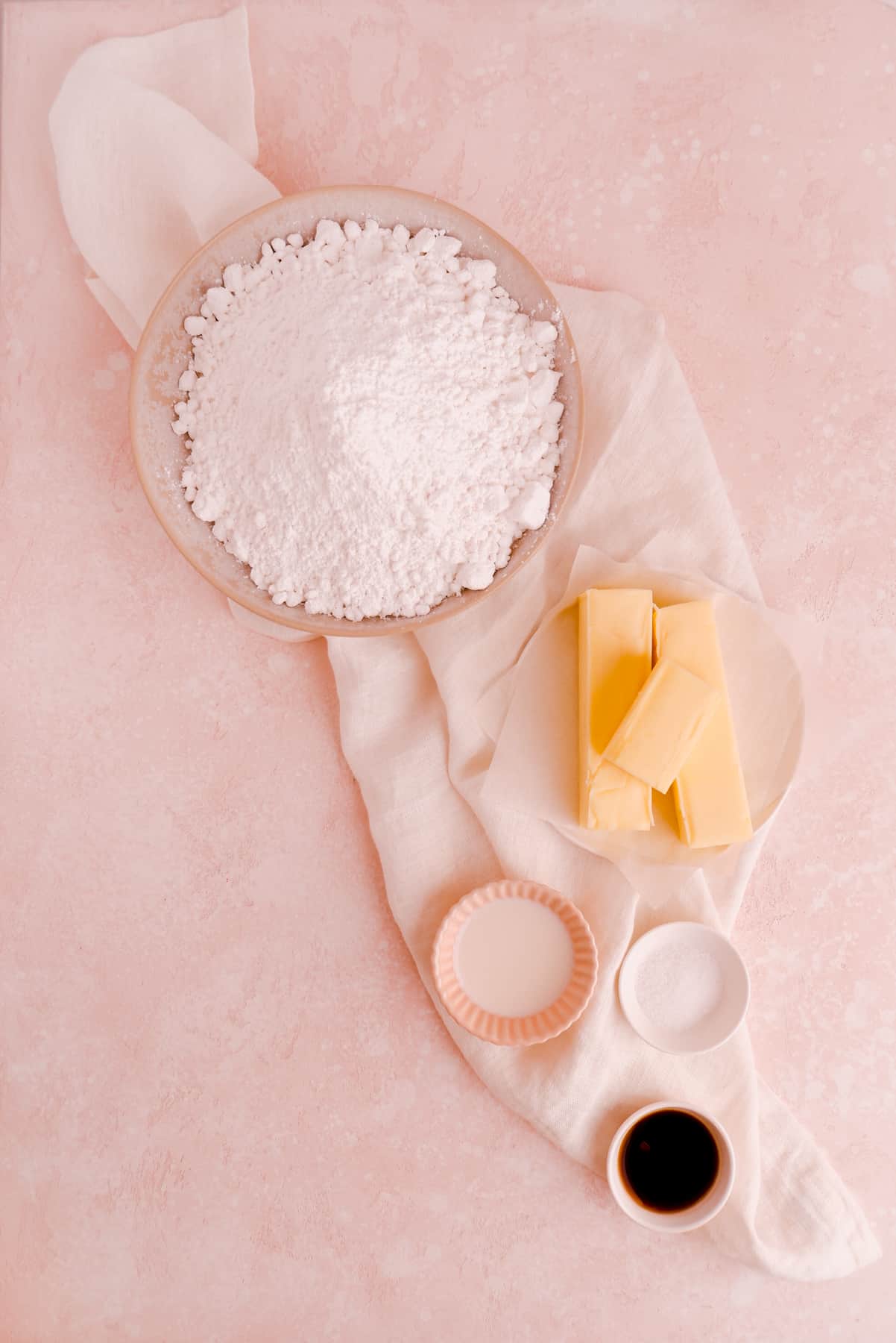 portioned ingredients shown in bowls needed for making easy vanilla buttercream frosting from scratch