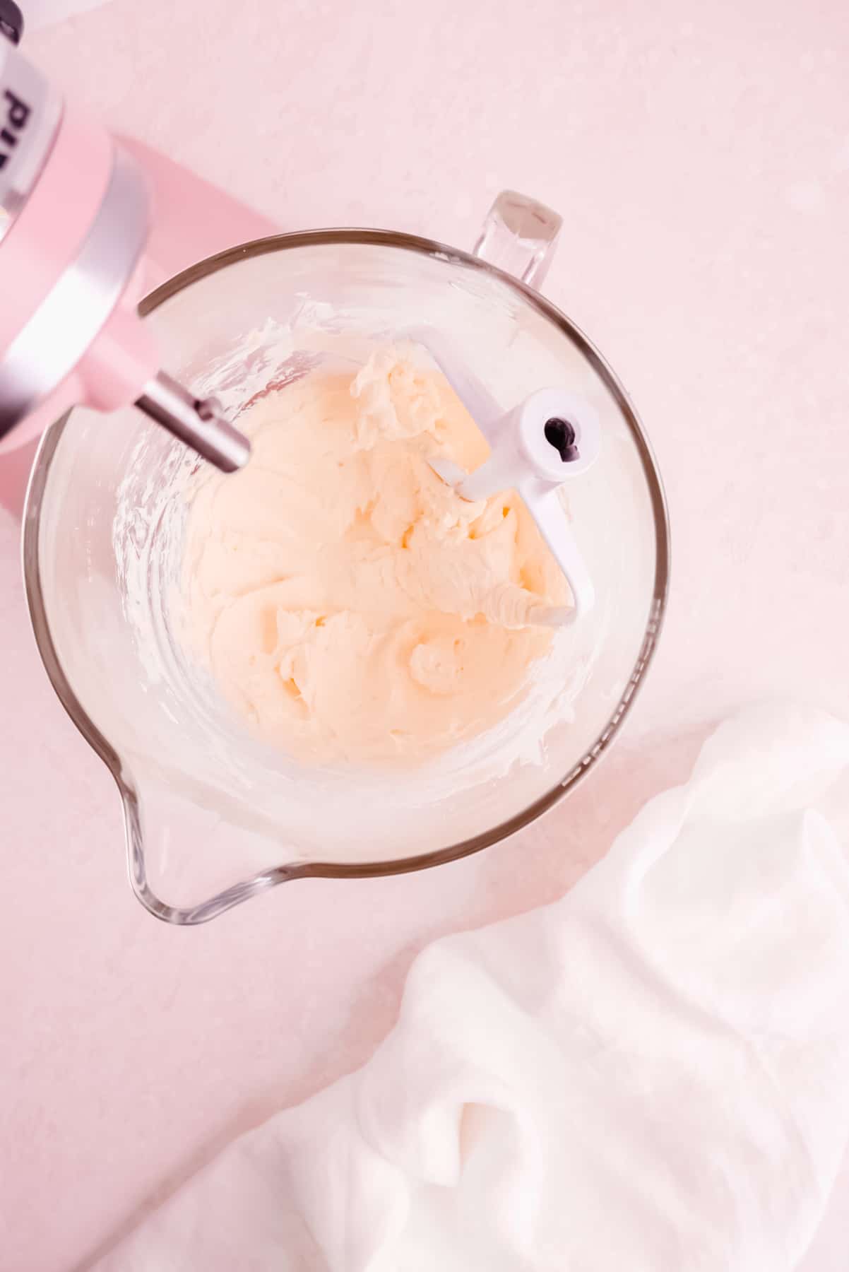 a kitchenaid mixer glass bowl of whipped butter for making easy vanilla buttercream frosting from scratch