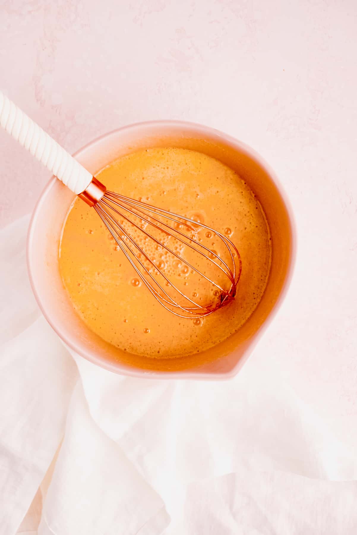 eggs and sugar mixed in a bowl with a whisk for gluten free brownie batter