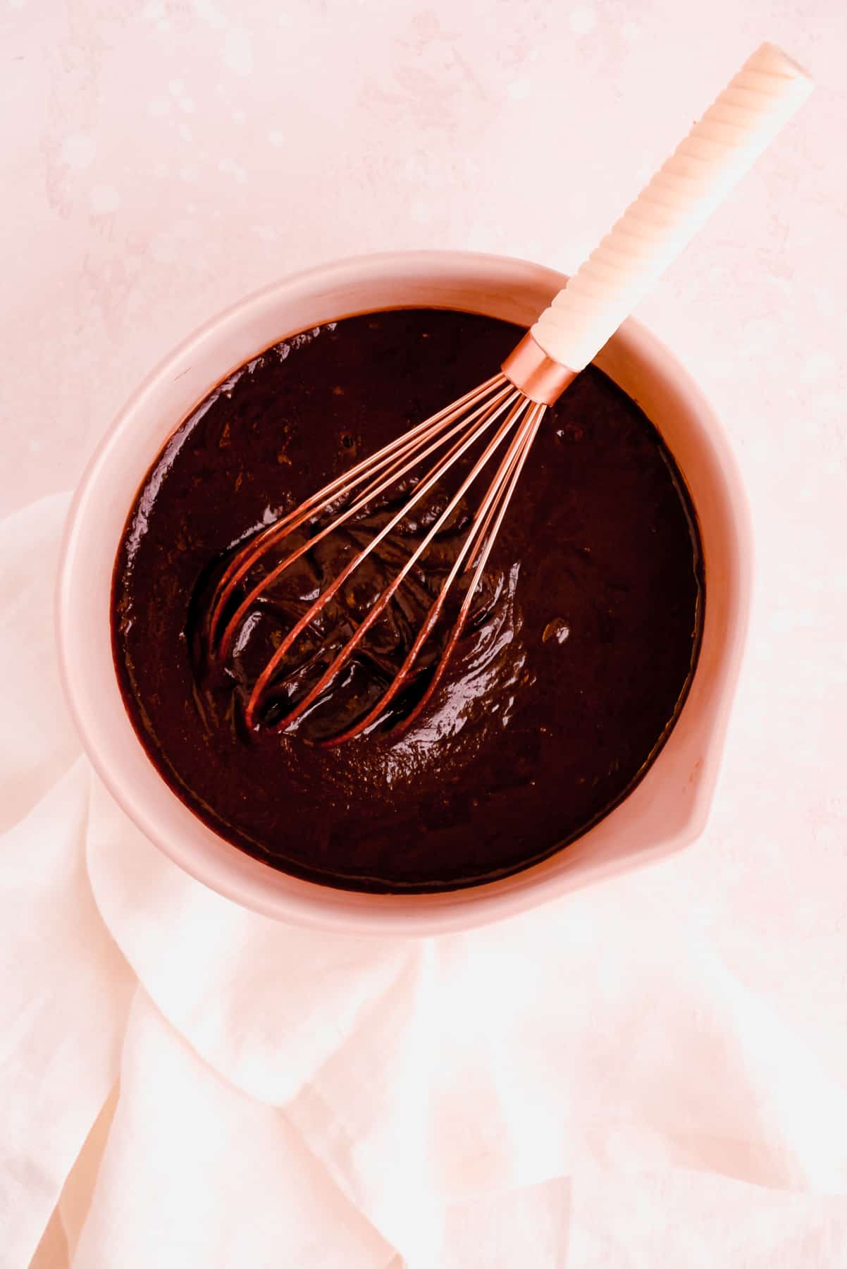 fudgy gluten free brownie batter without flour in a bowl with a whisk