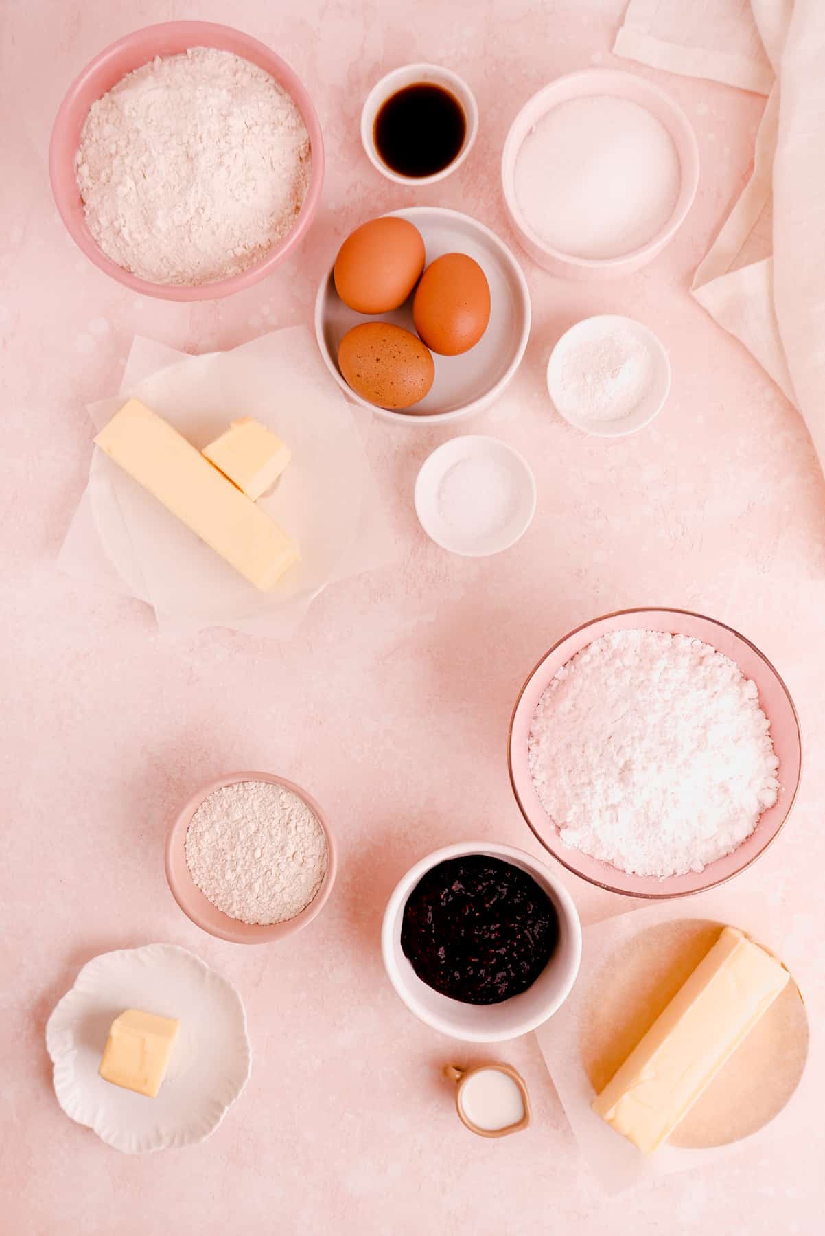 portioned ingredients shown in bowls needed for making mini victoria sponge cakes from scratch