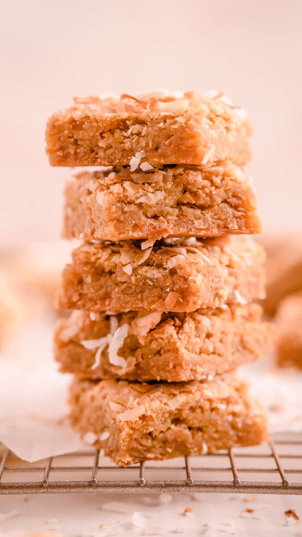 a stack of coconut butterscotch cookie bars on a wire rack