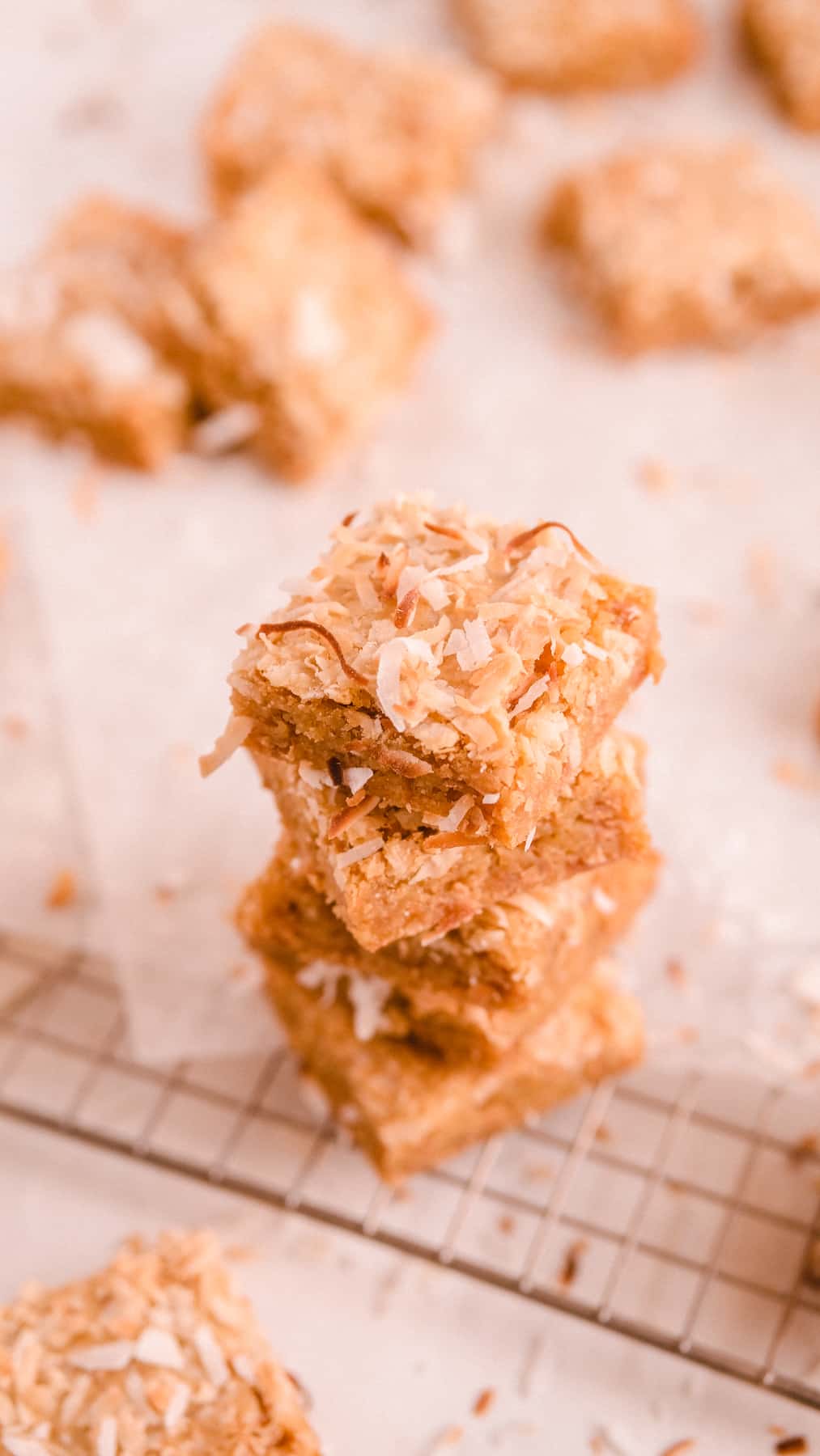 a stack of coconut butterscotch cookie bars on a wire rack