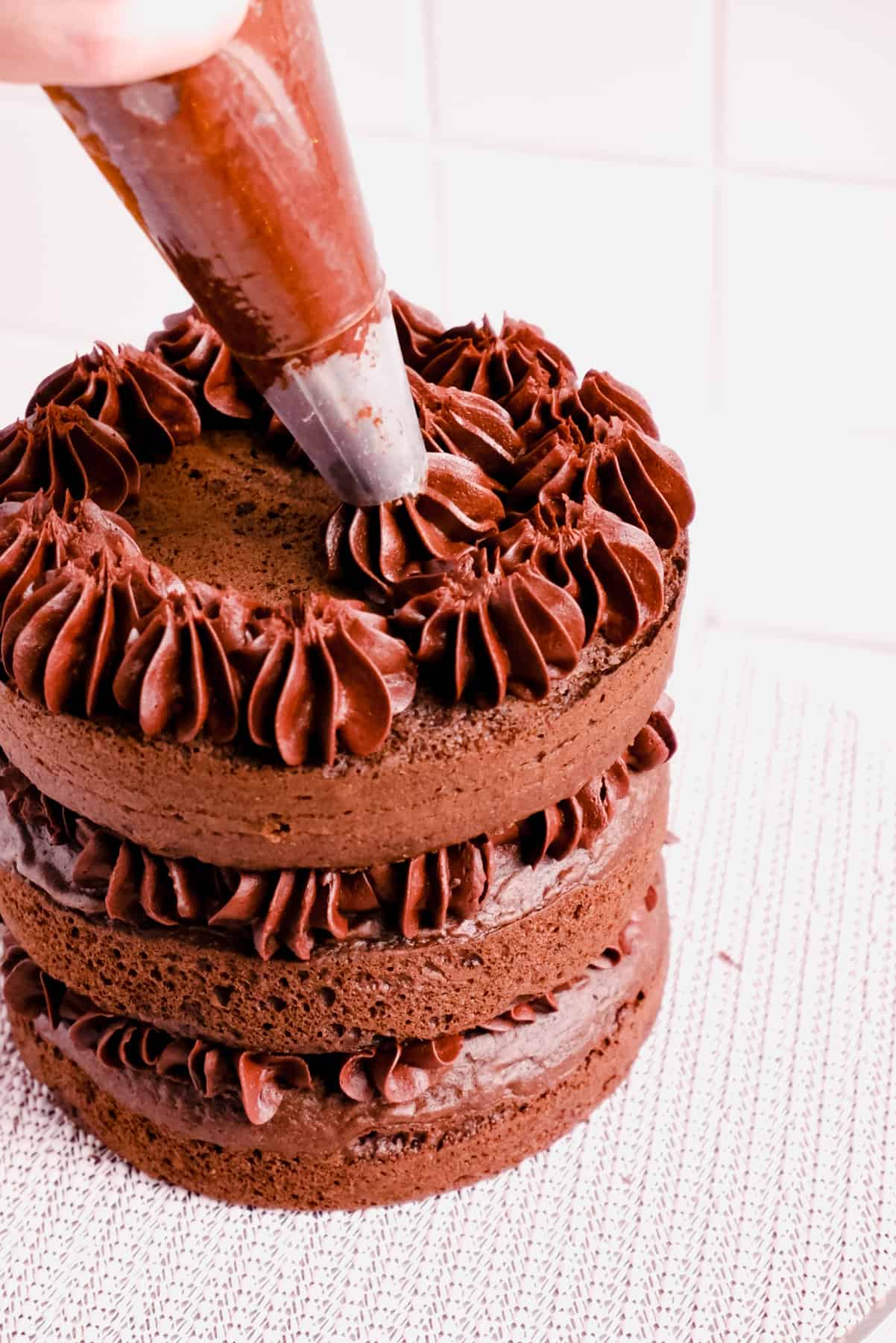 chocolate cake layers filled and topped with chocolate buttercream frosting