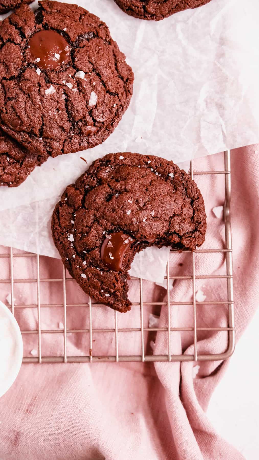 double chocolate chip cookies on a wire tray with a bite out of one