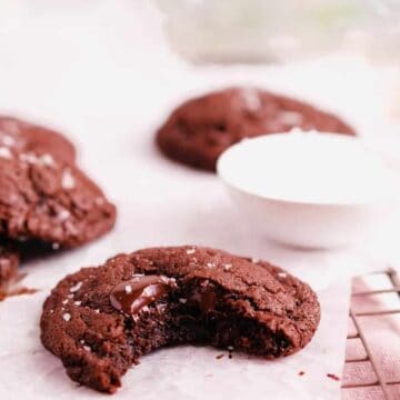 chocolate chip cookies on a wire tray with a bite out of one
