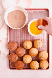 Cinnamon Donut Muffins on a cooling rack with butter and cinnamon and sugar