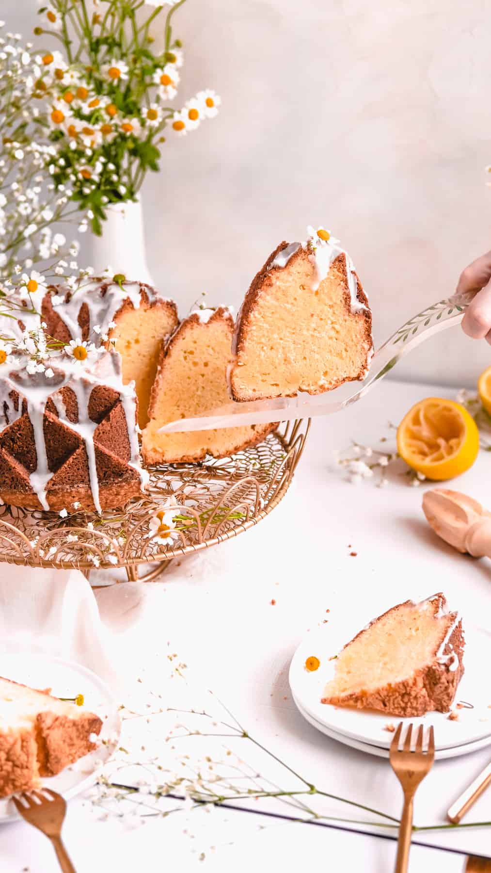 lemon bundt cake on a gold cake plate with lemons