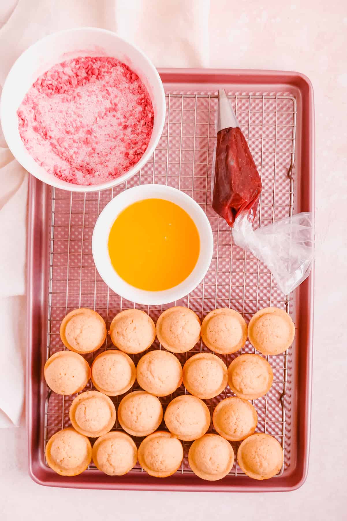 mini donut muffins with strawberry sugar and jam on a cooling rack