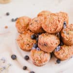 blueberry muffins with cinnamon streusel stacked up on a plate