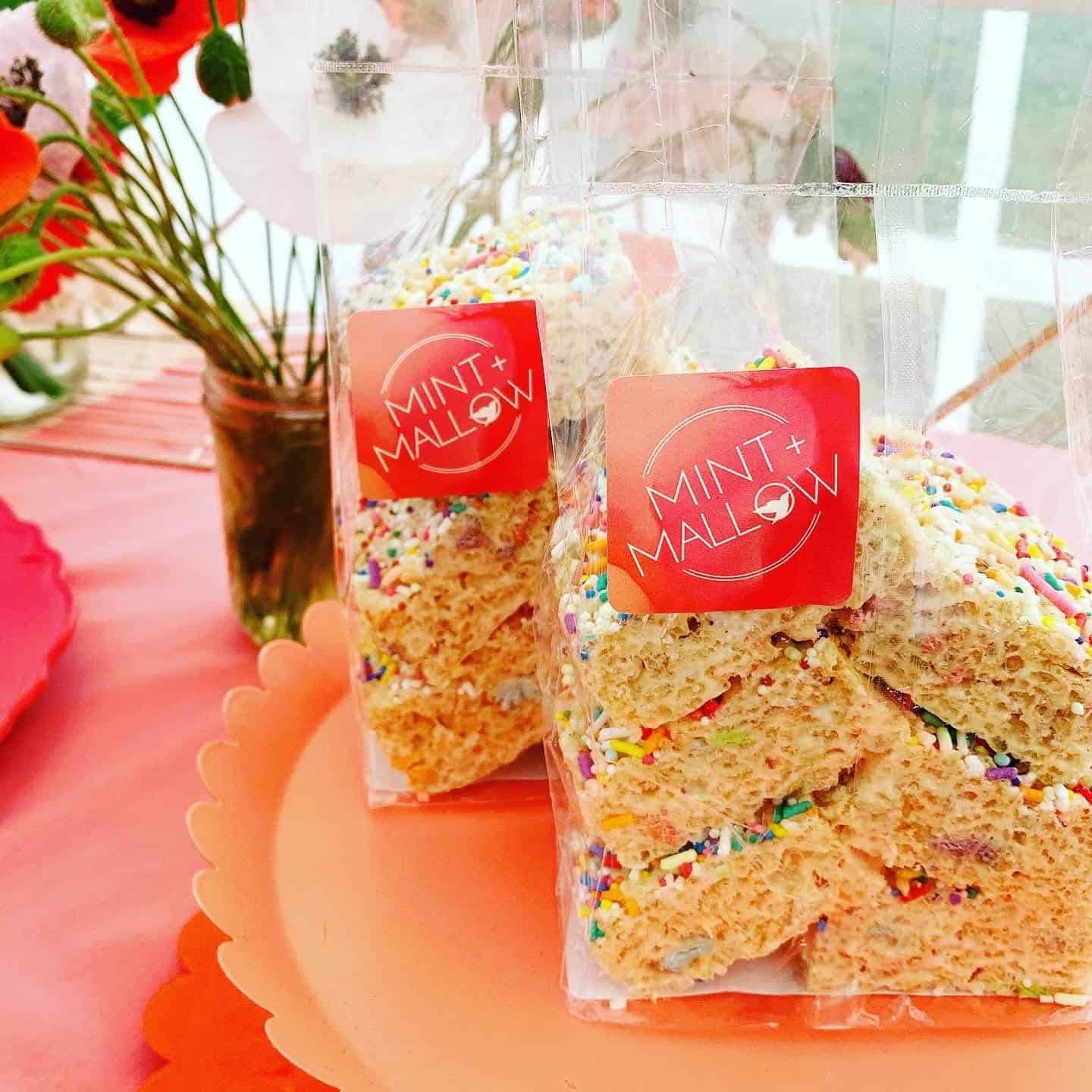 bags of rice krispie treats on an orange cake tray with poppies in the background