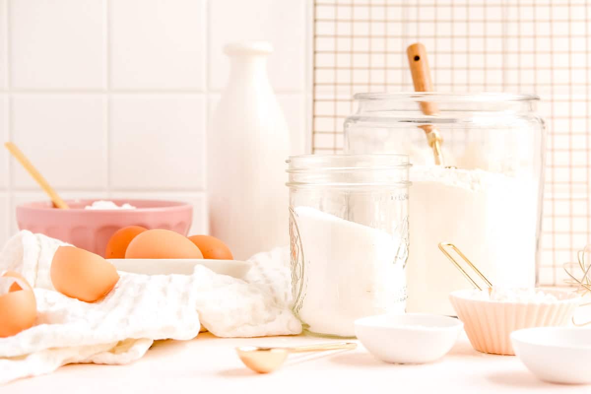 a table filled with baking ingredients, eggs and measuring utensils.
