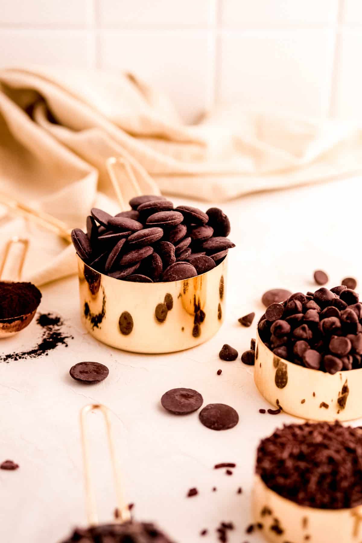 gold measuring cups piled high with chocolate ingredients