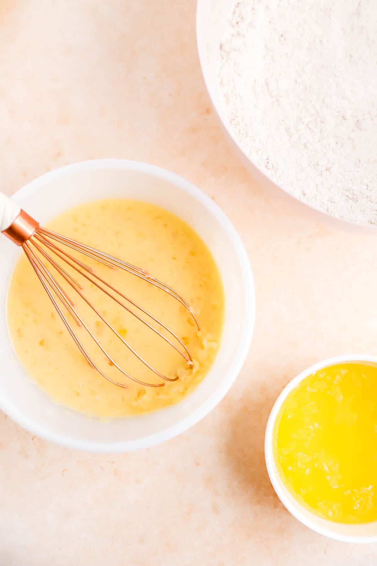 dry ingredients, wet ingredients and melted butter for carrot cake in separate mixing bowls.