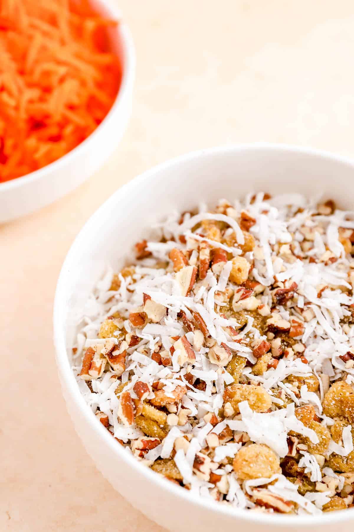 a blend of chopped pecans, golden raisins, and shredded coconut in a small bowl.