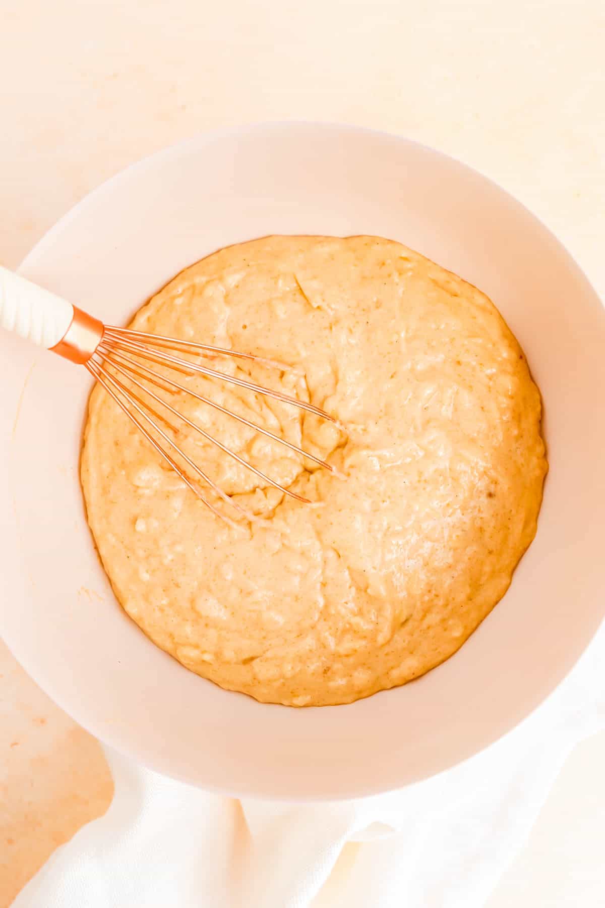 the cake batter base for old fashioned carrot cake in a bowl with a whisk.