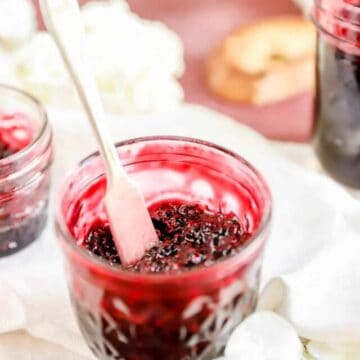 a jar of black raspberry jam from the top with a knife sticking out of it.