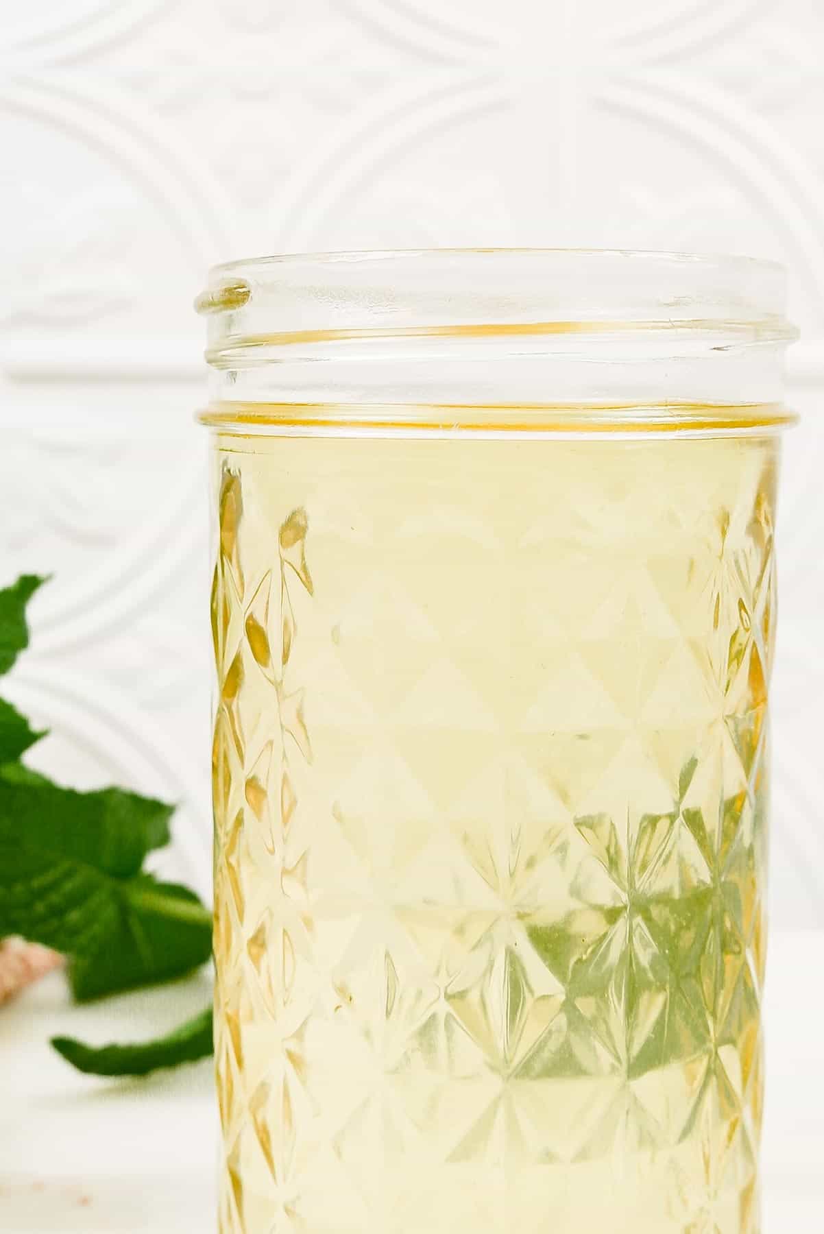 a mason jar of strained, clear fresh mint simple syrup.