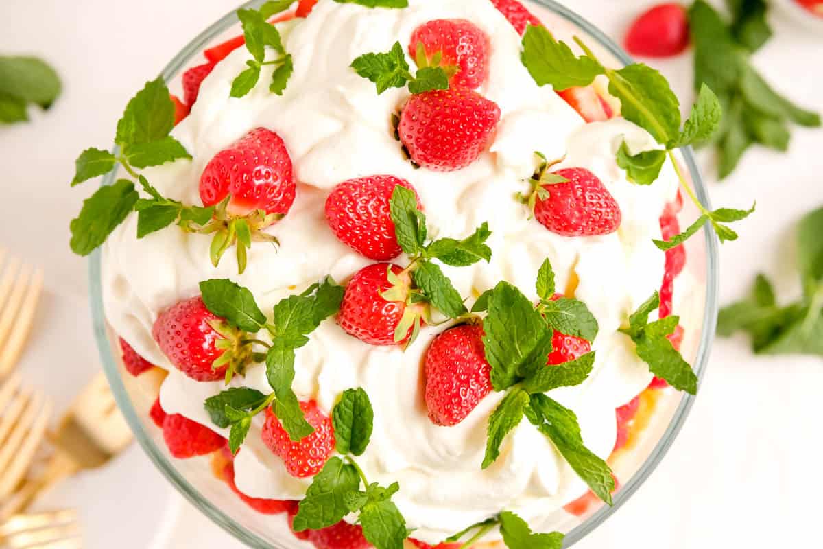 strawberry trifle with fresh mint garnished and shot from above with forks and mint leaves on the table.