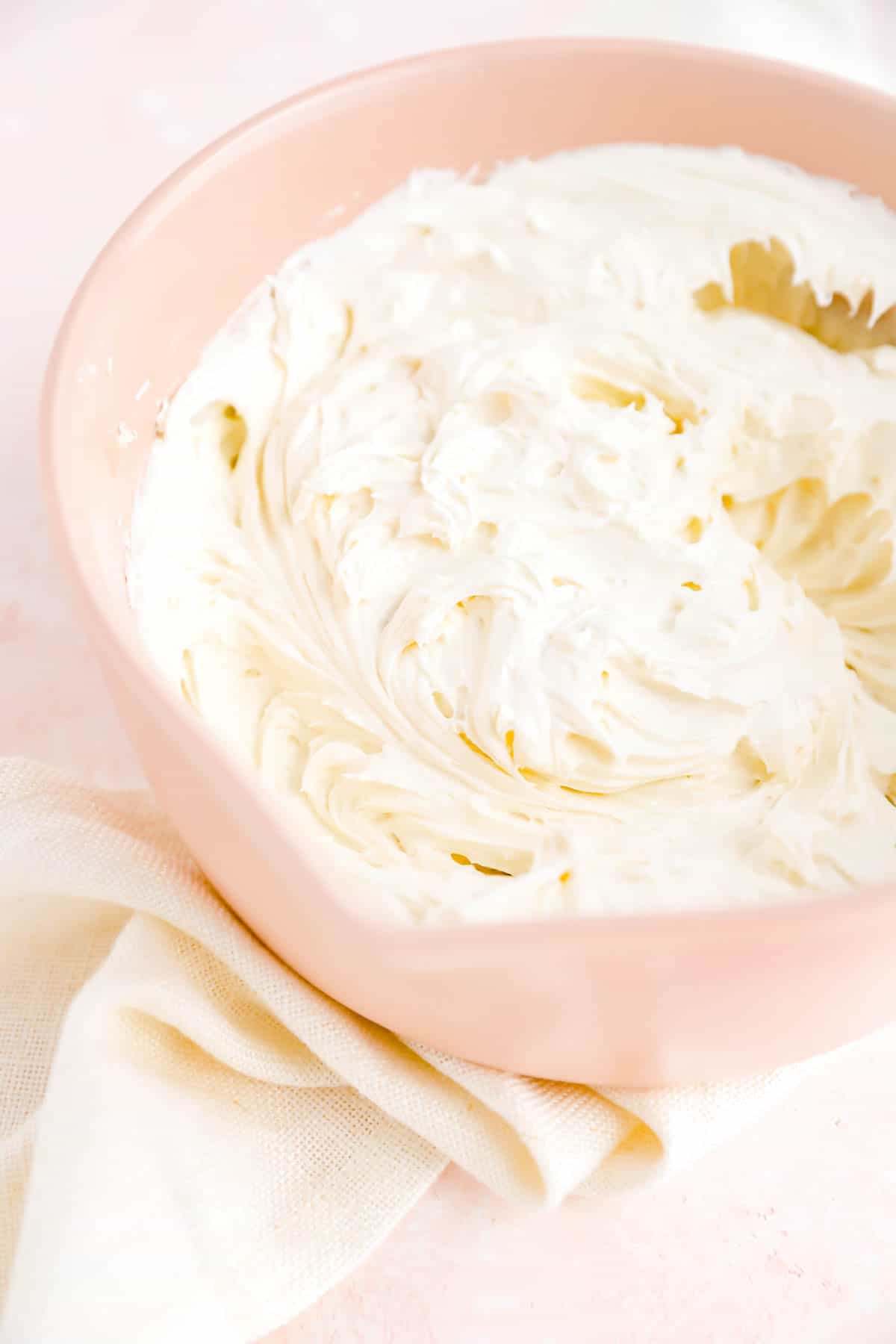 a bowl filled with freshly whipped cream cheese frosting.