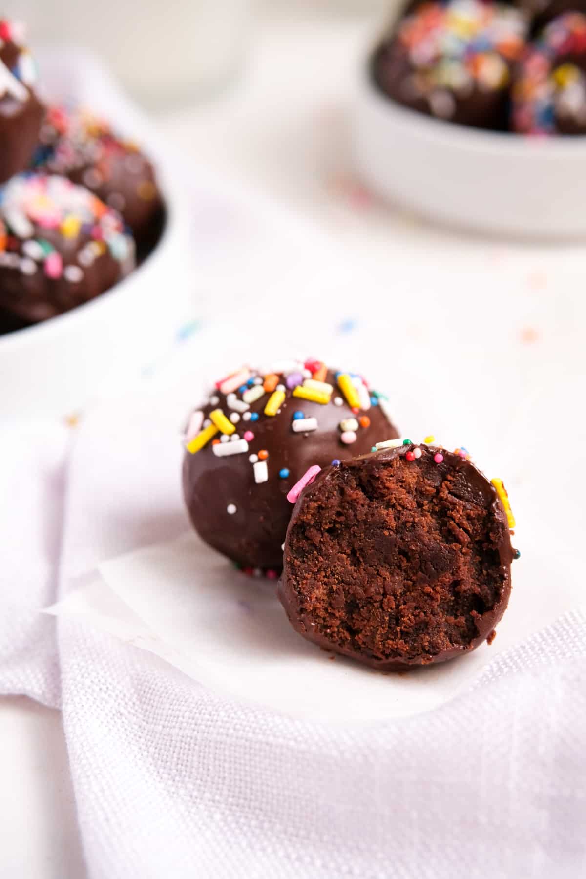 chocolate brownie truffles with rainbow sprinkles and a bite out of it