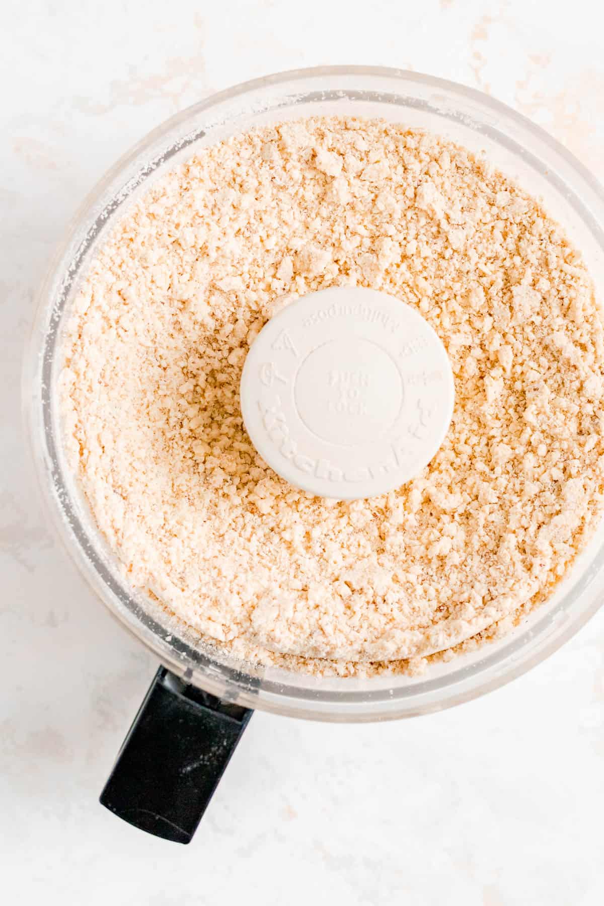 dry ingredients, nuts, and cold butter blended together into crumbs in a food processor bowl