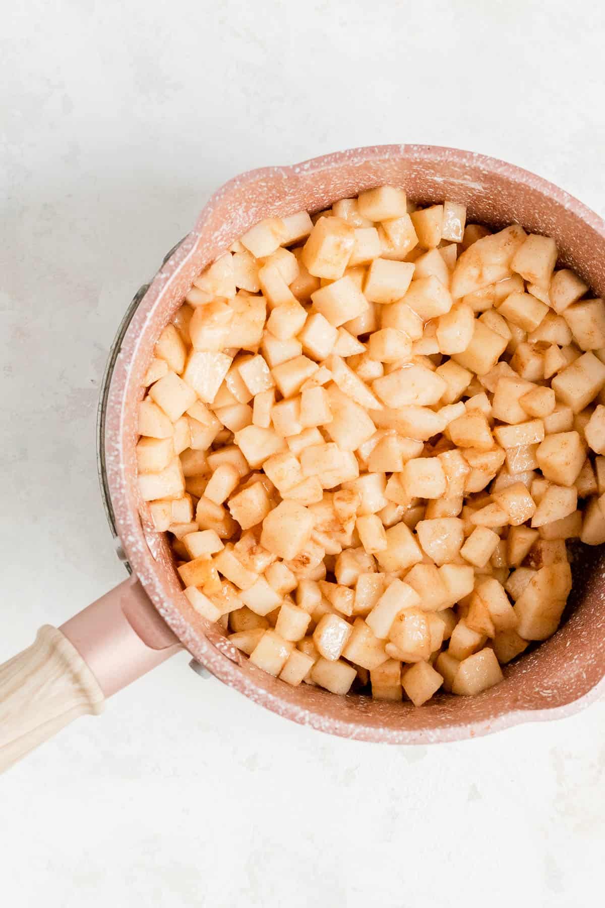raw apples in a copper pot with butter and sugar