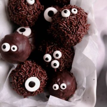 chocolate brownie truffles with sprinkles and candy eyes piled in a white dish