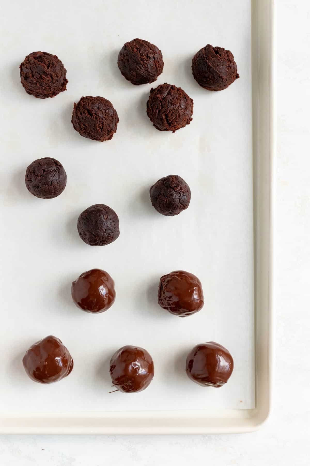 scooped rolled and coated brownie turffles on a white baking sheet