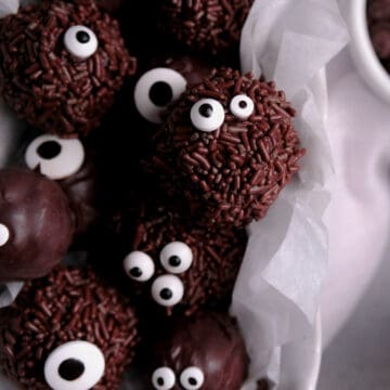 chocolate brownie truffles with sprinkles and candy eyes piled in a white dish
