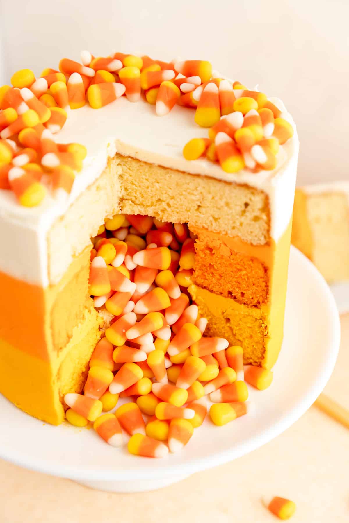 close up of slices candy corn decorated cake with candy corn spilling out of middle