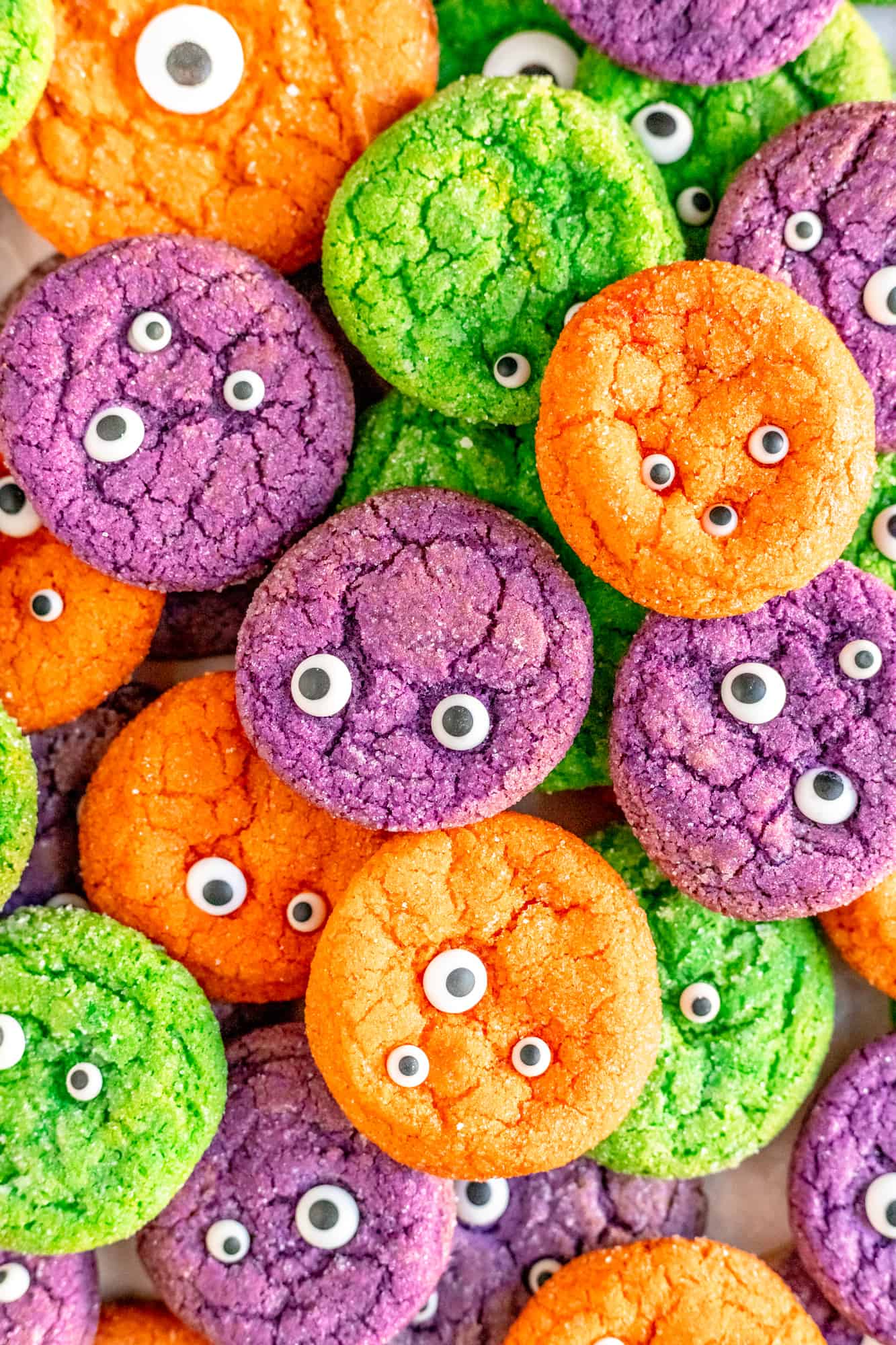 purple orange and green monster eyeball sugar cookies piled on each other