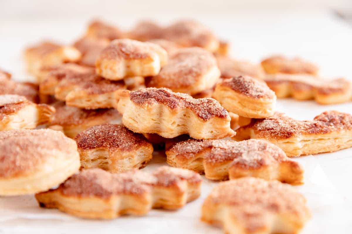 a pile of pie crust cookies in a leaf shape from the side showing the flaky layers