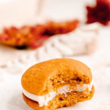 pumpkin whoopie pie with cream cheese filling with a bite out of it