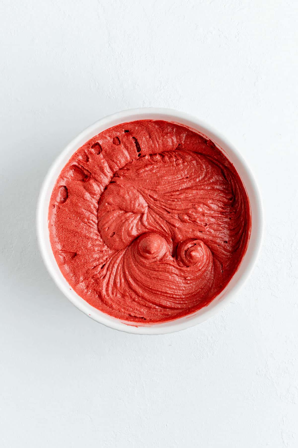 red the cake batter in white bowl on white background.