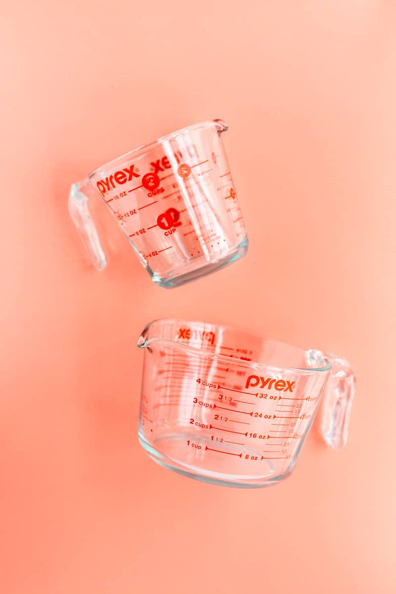 a 2 cup and 4 cup Pyrex picture on side on coral background.
