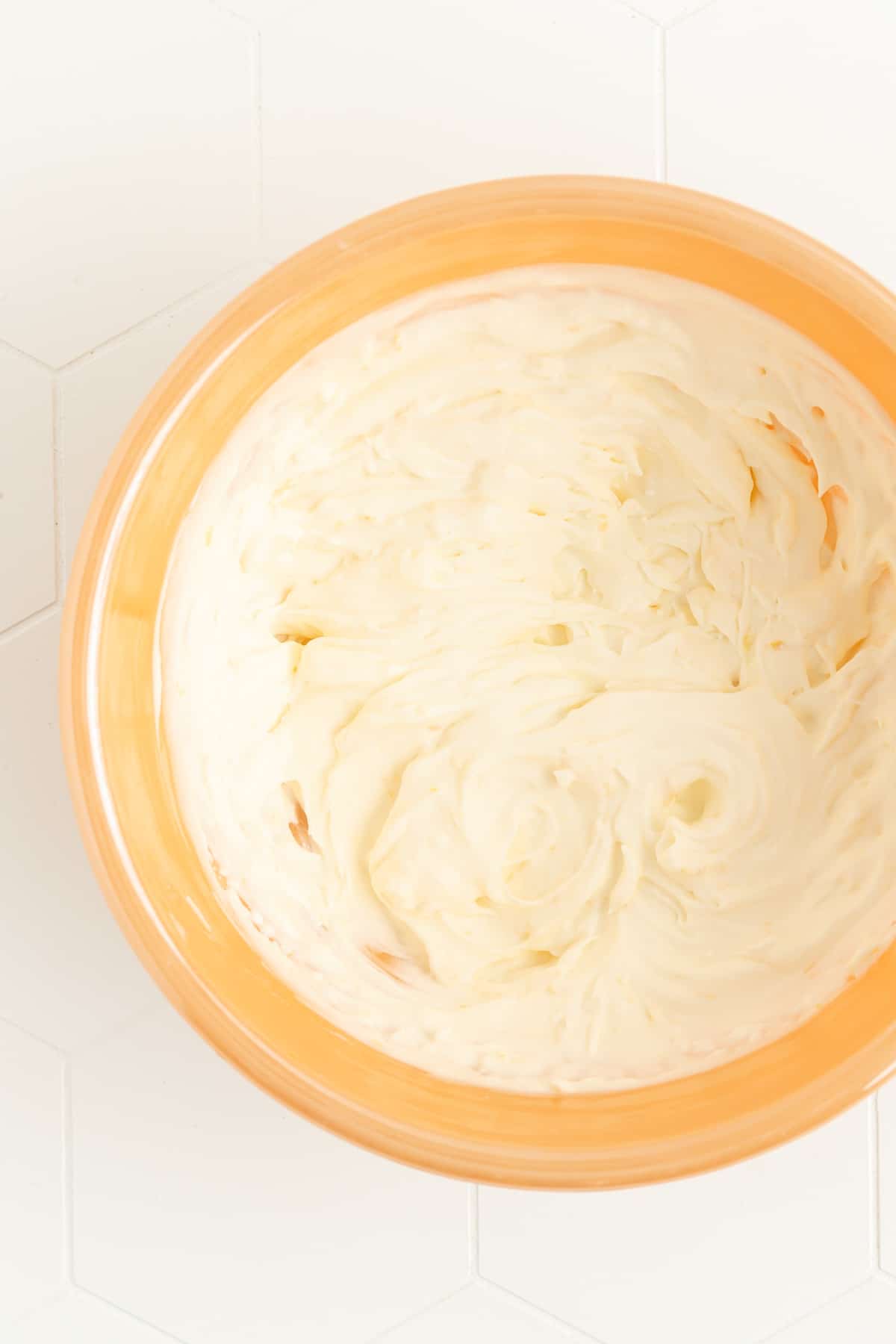 thick fresh lemon whipped cream in orange mixing bowl