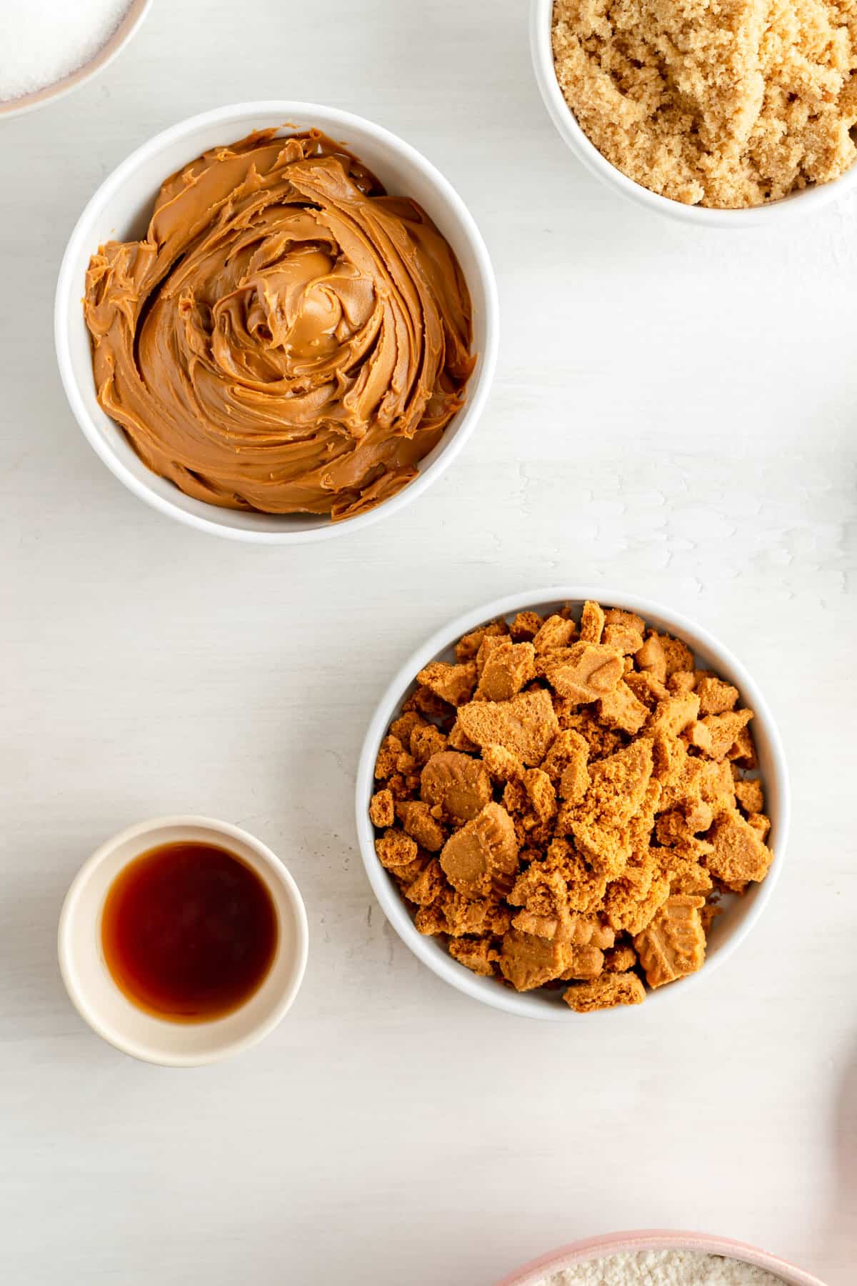 a bowl of crushed biscoff cookies and a bowl of biscoff butter with other ingredients.