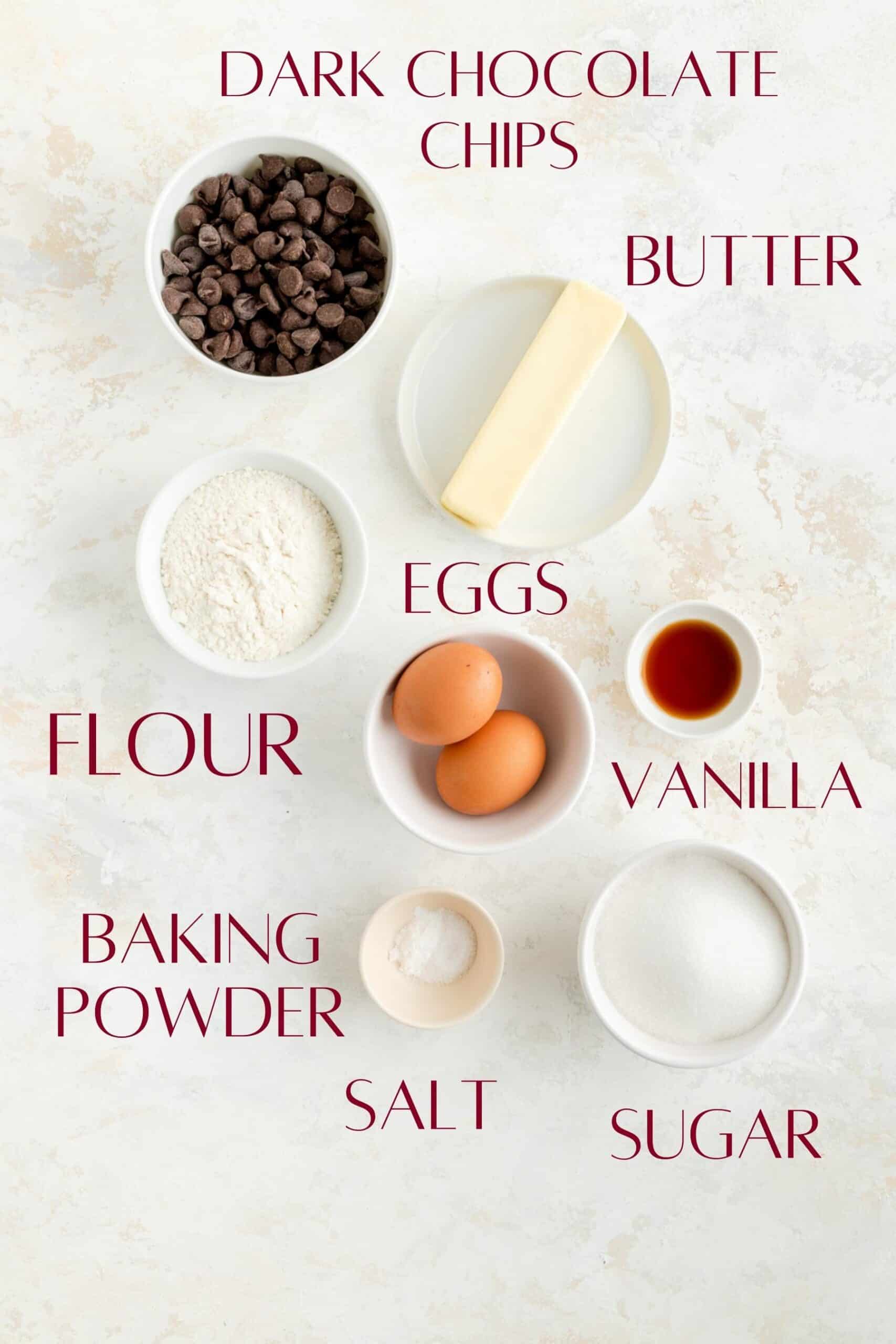 labeled brownie batter ingredients in individual bowls on a white background.