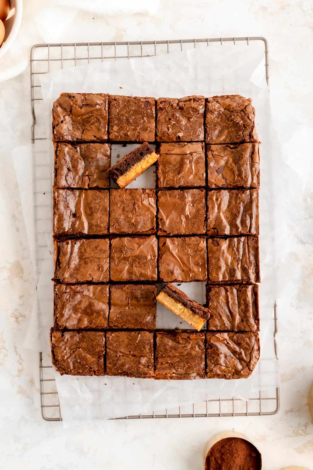 A full pan of brownies cut on a cooling rack with two brownies on their side.