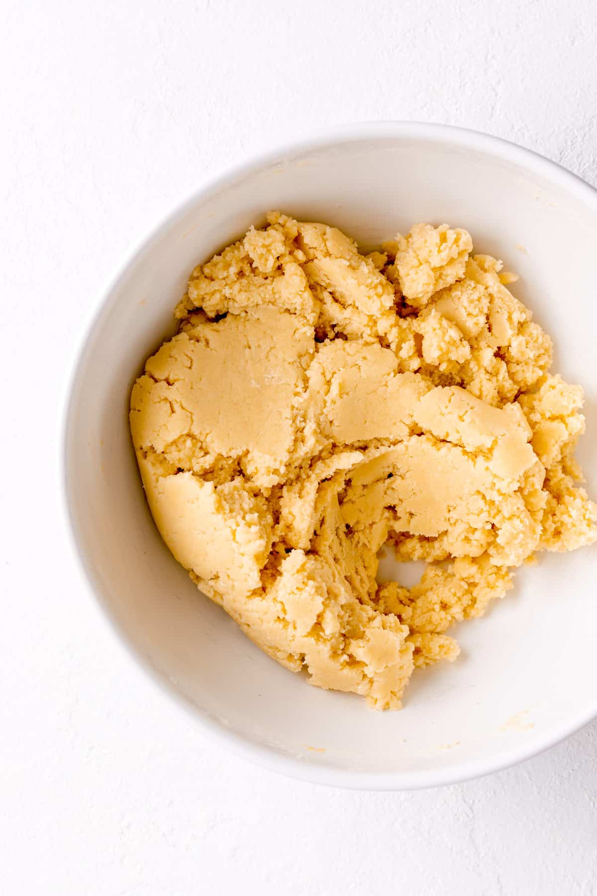 final sugar cookie dough in a white bowl on a white background.