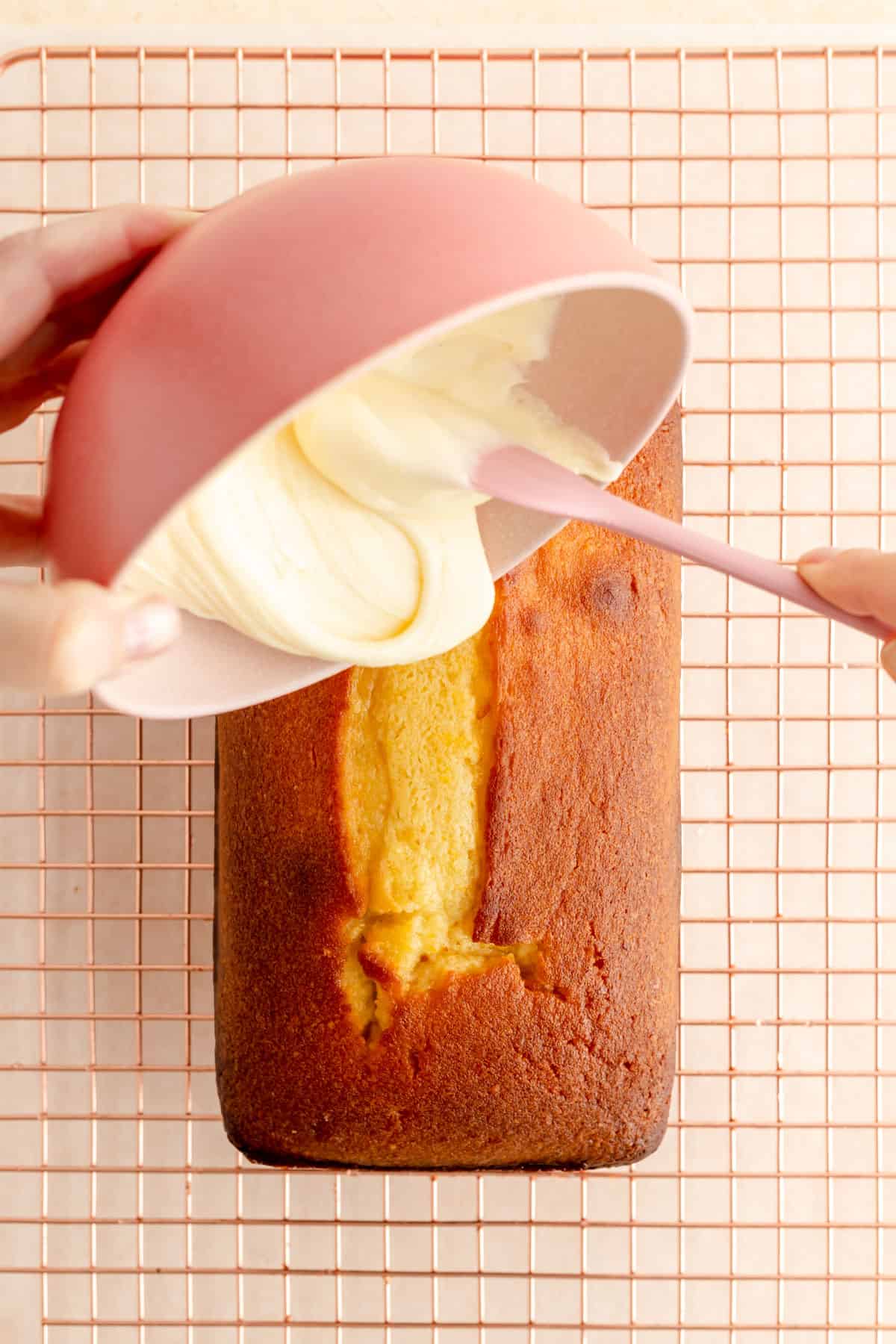 a bowl of orange glaze being poured onto a citrus pound cake.