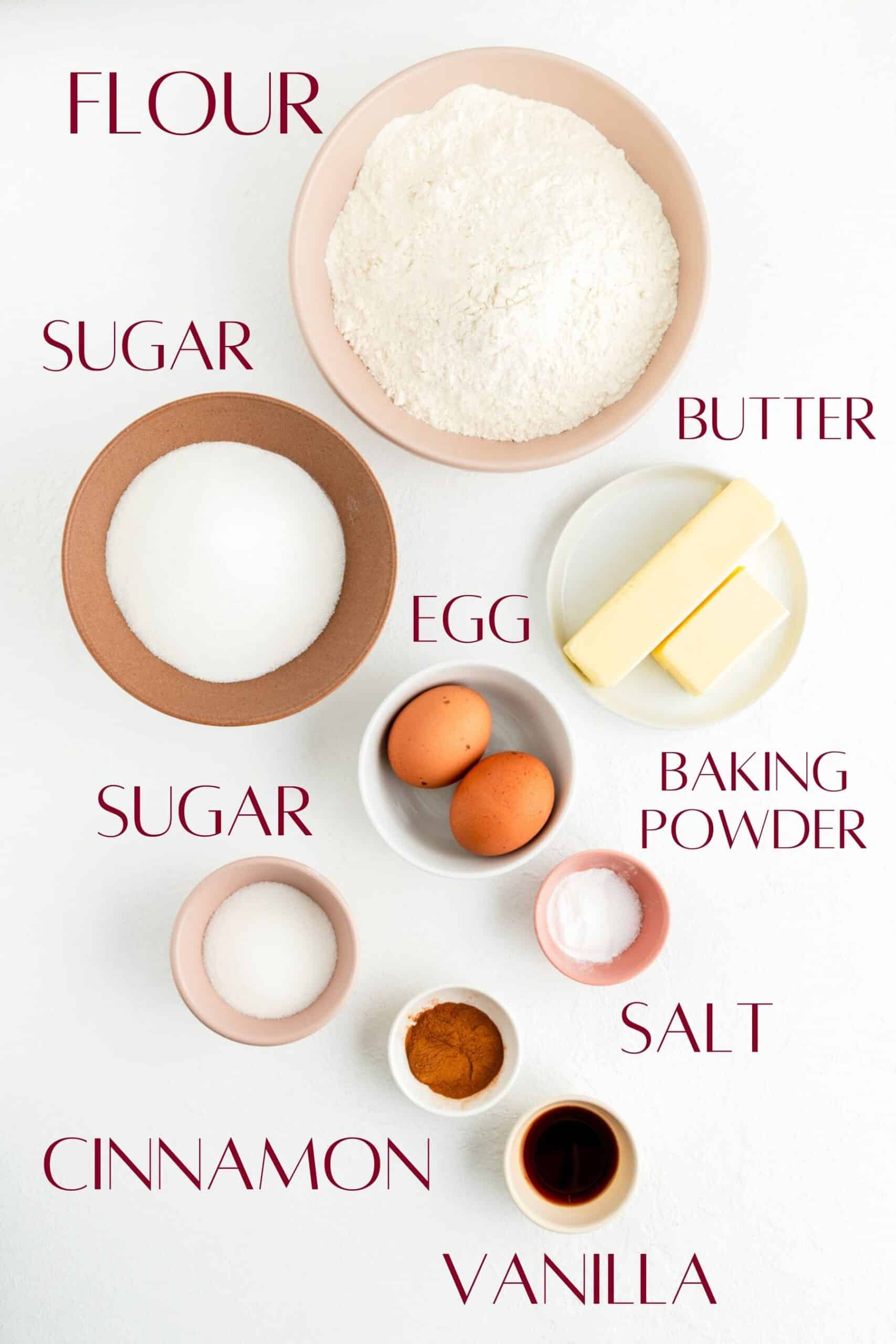 labeled snickerdoodle cookie ingredients in individual bowls on a white background.