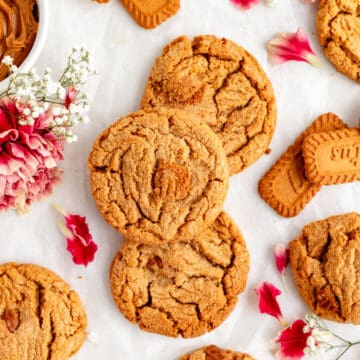biscoff butter cookies from above with carnations, petals, and baby's breath on white background.