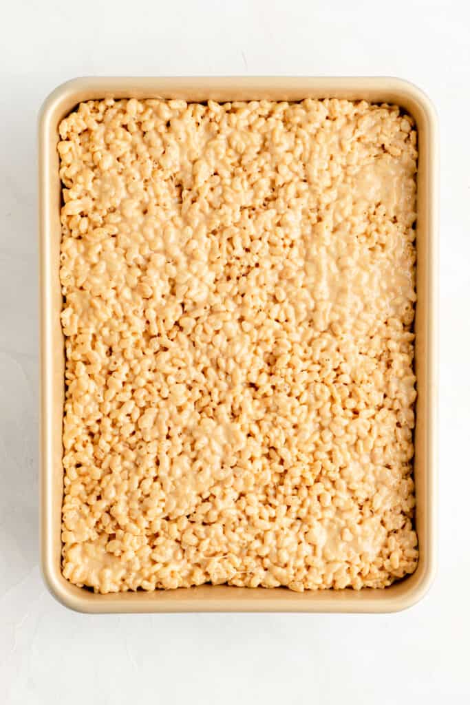 A gold pan filled with pressed peanut butter rice krispie treats.