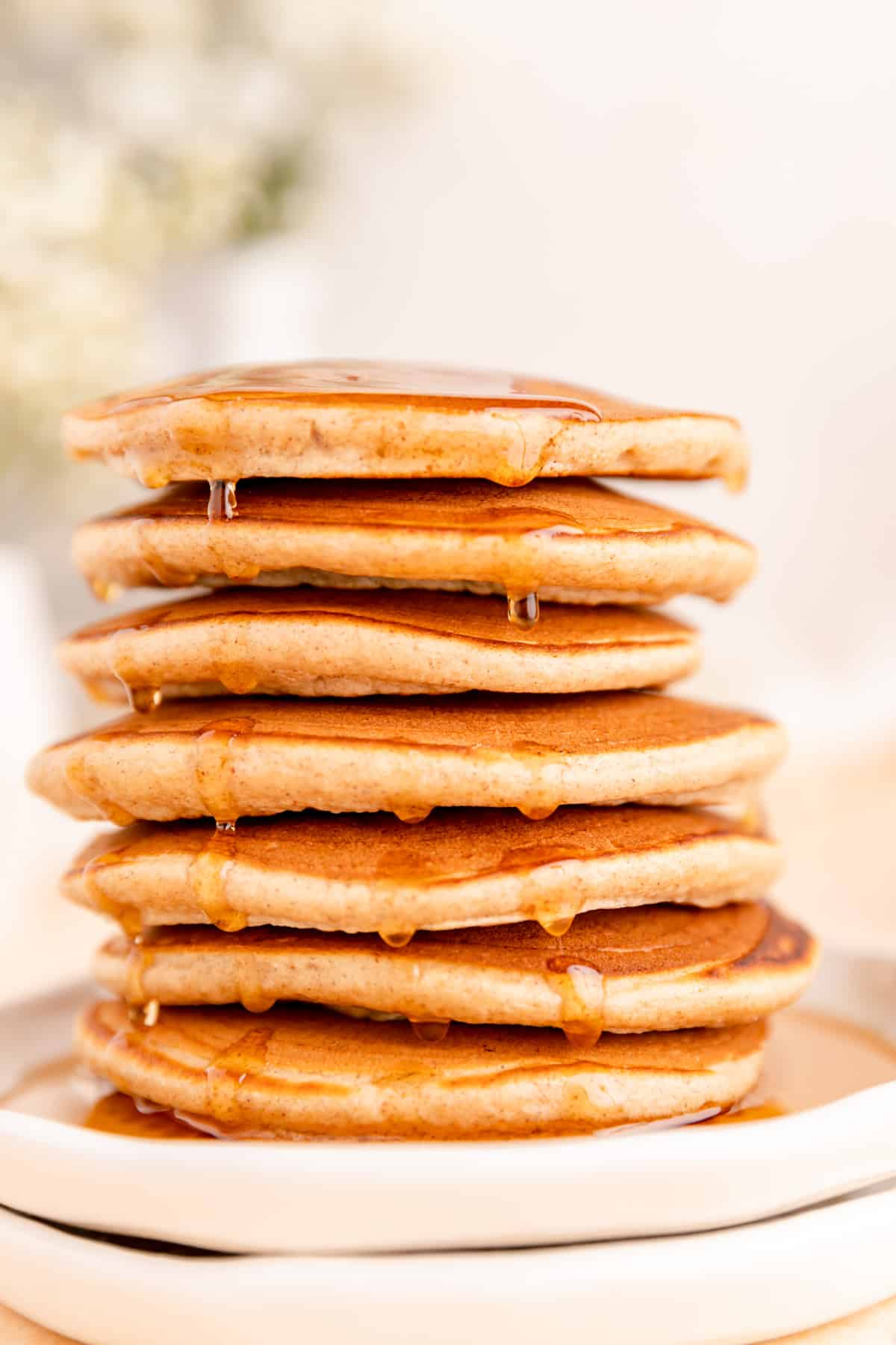 Close up a French toast pancakes stack with lots of syrup dripping down side.