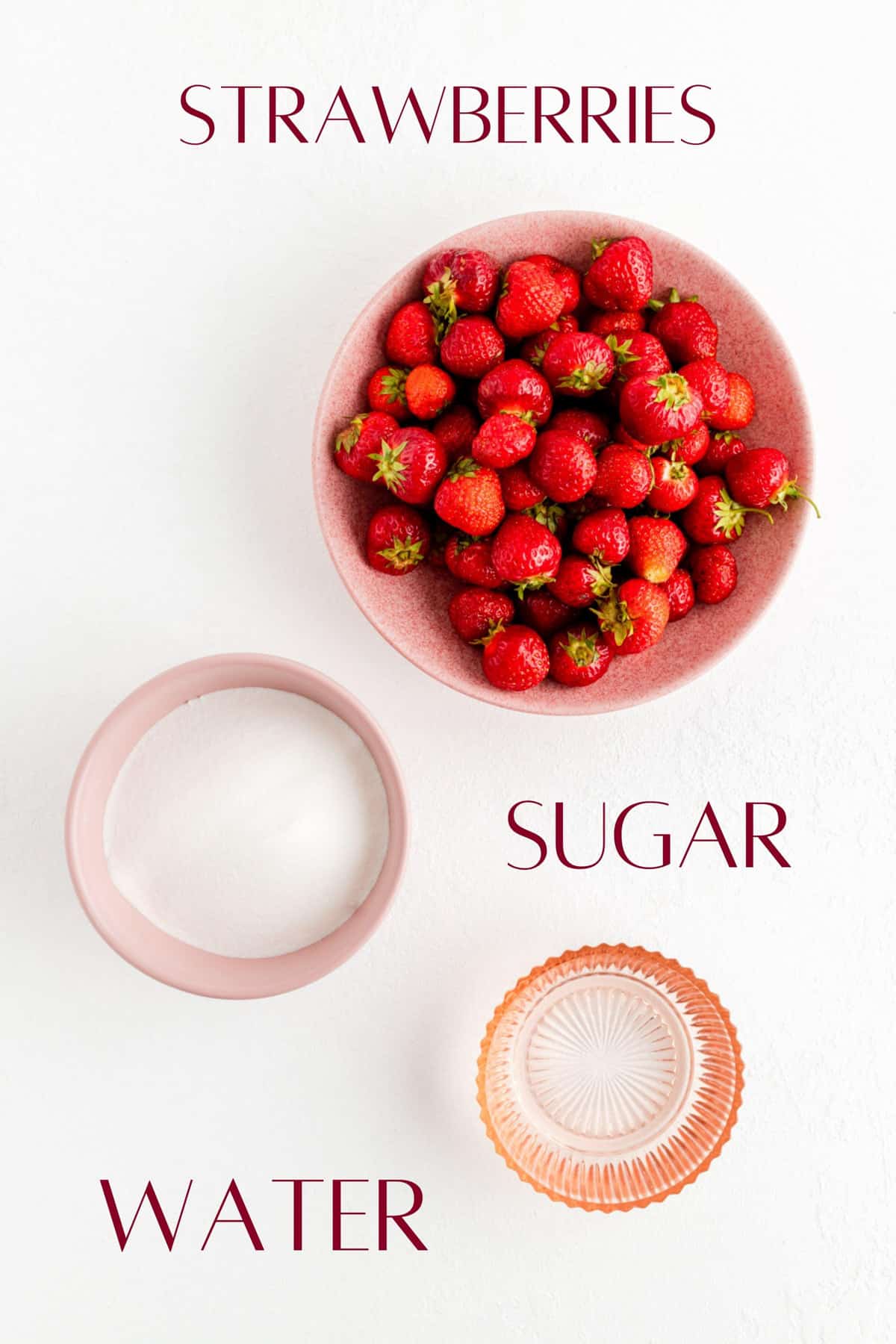 Ingredients for strawberry simple syrup in individual bowls on white background.
