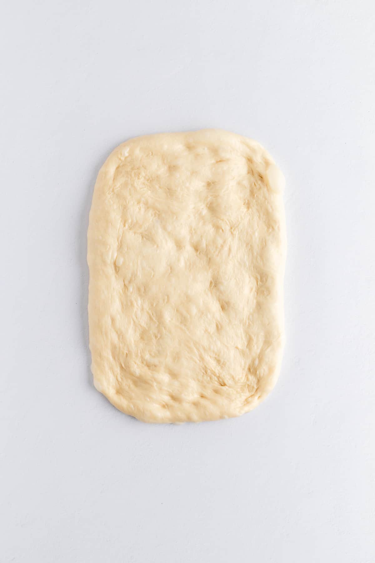 deflated brioche dough on a white background.